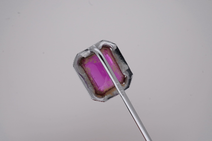 A North American? 10k white metal and single stone emerald cut synthetic ruby set stick pin, 55mm, gross weight 1.1 grams. Condition - fair to good